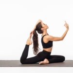 Sporty young woman doing yoga practice isolated on white background - concept of healthy life and natural balance between body and mental development